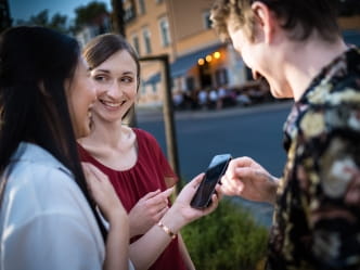 drei Personen mit einem Smartphone